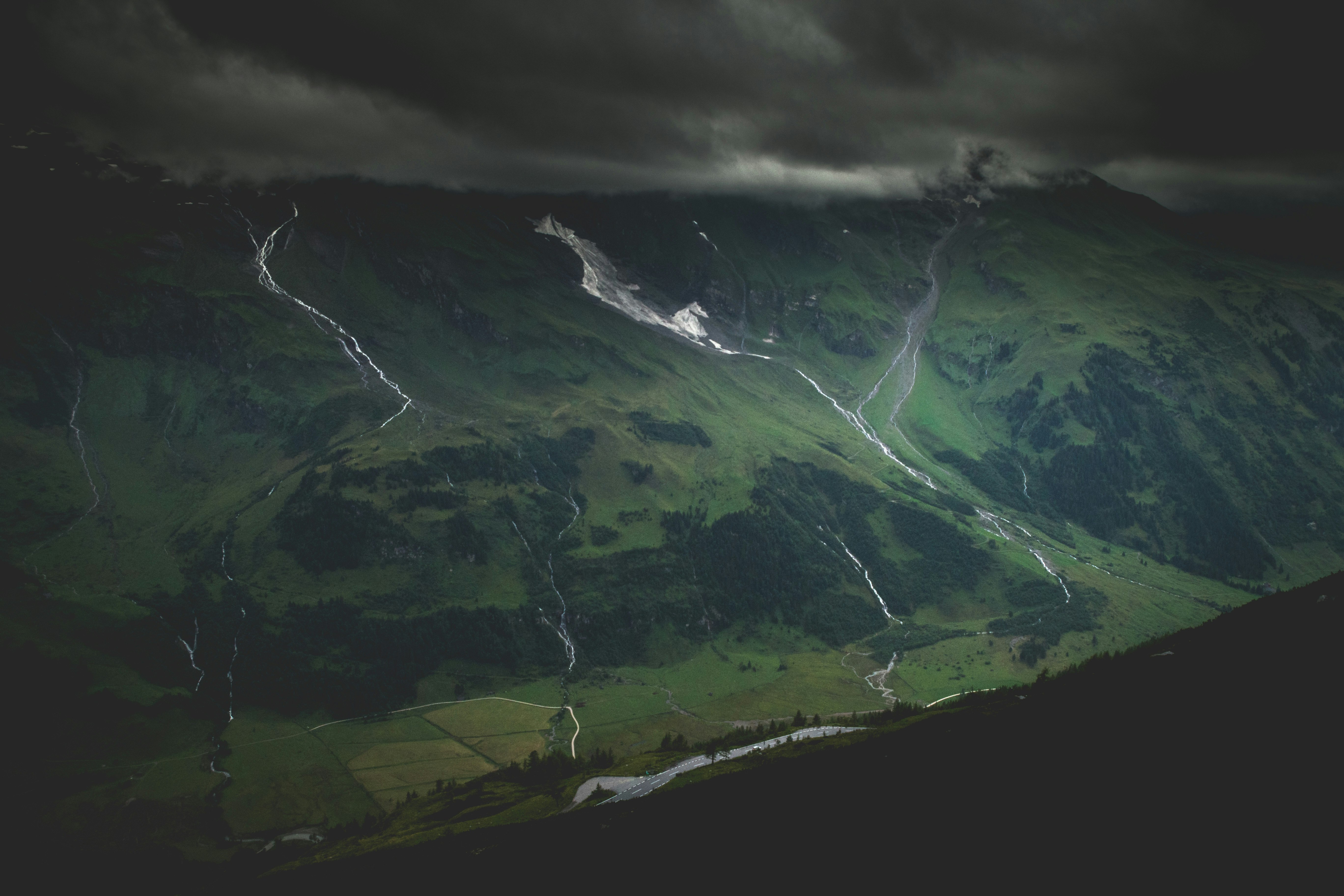 green mountain under dark cloudy sky